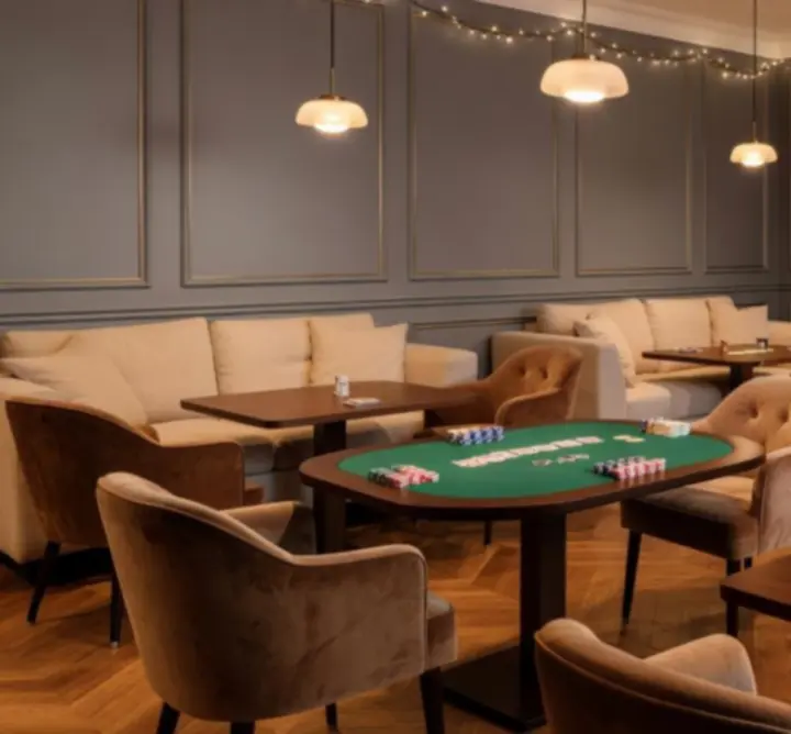 Espace indoor chaleureux préparé pour une soirée privée avec tables de jeux.